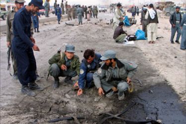 Afghan police investigate at the scene of a suicide car bomb in the southern city of Kandahar, Afghanistan March 30, 2006. A suicide car-bomber was killed in southern Afghanistan on Thursday when his explosives went off prematurely as he approached a Canadian military convoy, police said