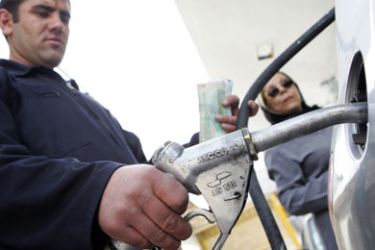 An Iranian motorist pumps gasoline for a woman at a petrol station in downtown Tehran, 19 April 2006. Iran's President Mahmoud Ahmadinejad has called on oil producers,