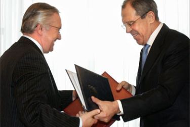 Ukrainian Foreign Minister Boris Tarasyuk (L) exchanges documents with his Russian counterpart Sergey Lavrov during the signing ceremony in Moscow, 21 April 2006.