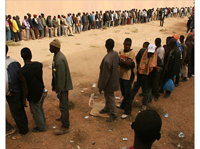 r_African immigrants stand in line at a camp in the desert town of Bourfa, some 500 km southeast of the Moroccan capital of Rabat, in this October 10, 2005