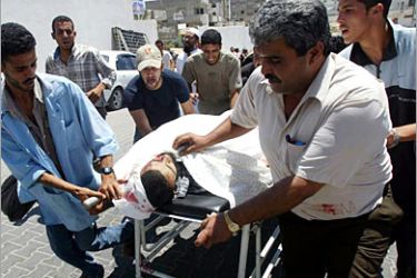 REUTERS/ Palestinians wheel one of two Palestinian militants killed by Israeli missiles into a hospital in Khan Younis, south of Gaza Strip, July 10, 2006. An Israeli helicopter gunship fired two