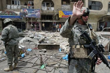 US soldiers check the site where five people were killed and 10 wounded in a car bombing and a suicide bombing near the heavily fortified Green Zone, the seat of the Iraqi government and headquarters