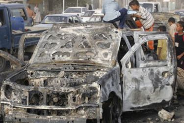 Children play on a burnt military vehicle along a road in Diwaniya, 180 km (112 miles) south of Baghdad, August 27, 2006. Eight civilians have been killed in clashes between