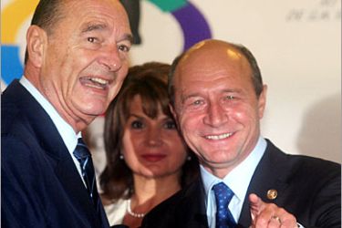 REUTERS/ Romanian President Traian Basescu (R) speaks to his French counterpart Jacques Chirac (L) during the official welcoming ceremony at the beginning of the two-day