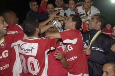 afp - Tunisian Etoile team poses with a trophy after their Final African Cup Confederation match against F Rabat, 01 December 2006