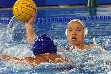 f_A file photo taken 19 December 1998 shows Han Zhidong of China (R) holding the ball while Singapore's Yeo Kok (L) attempts to block him during the water polo final round match at the 13th Asian Games at the Thammasat University Sports Complex. China water polo player Han Zhidong was taken to hospital after collapsing poolside during