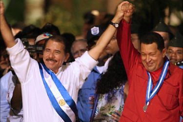 f_Daniel Ortega (L) and Hugo Chavez, presidents of Nicaragua and Venezuela respectively, hold hands and wave 10 January 2007 in Managua during the ormer's inauguration