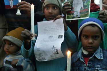 f_Indian children hold candles and photographs of missing children during a candle lit vigil in New Delhi, 14 January 2007, to demand justice for the parents of missing children and victims of the Nithari serial killings.
