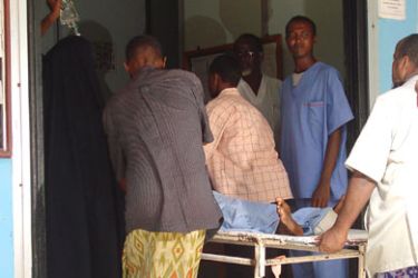 An unidentified Somali man is wheeled on a stretcher at the Madina hospital in Mogadishu after been wounded by a mortar shell, 24 January 2007.