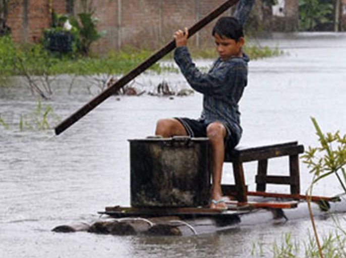 A Bolivian boy navigates his raft through flooded streets, as heavy rains attributed to the El Nino weather phenomenon continue to flood a large part of Bolivia's eastern lowlands