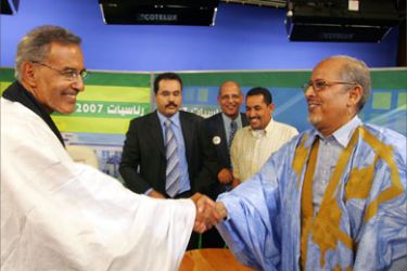 Mauritania's presidential candidates, former cabinet minister Sidi Ould Cheikh Abdellahi (R) and longtime opposition politician Ahmed Ould Daddah, shake hands before a debate in the studios of a TV station in Nouakchott, 22 March 2007