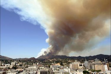 f_Smoke rises from a brush fire near the Hollywood hills in Hollywood, California, 30 March 2007. Some 200 firefighters were deployed as helicopters dropped chemicals and water