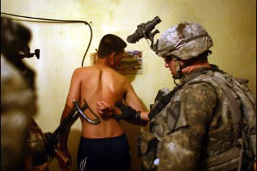 R/A U.S. soldier detain an Iraqi man during a night raid in Baquba early June 30, 2007. REUTERS/Goran Tomasevic (IRAQ)