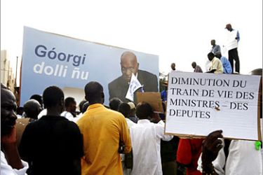 AFP / People hold placards as the walk pas a poster of Senegalese President Abdoulaye Wade (C) 27 July 2007 during a demonstration calling for a drop in the prices of "goods of