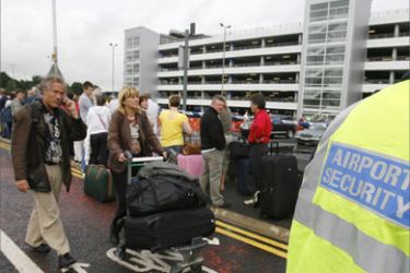 Airline passengers walk past security at Glasgow airport, Scotland July 1, 2007.