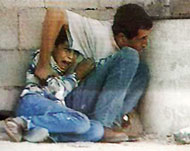 الطفل محمد الدرة مع أبيه قبيل استشهاده(الجزيرة-أرشيف)