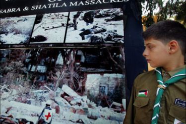 afp : A Palestinian scout looks at a poster showing images of the 1982 Sabra and Shatila massacre during a ceremony to mark the 25th anniversary of the event, 16 September 2007,