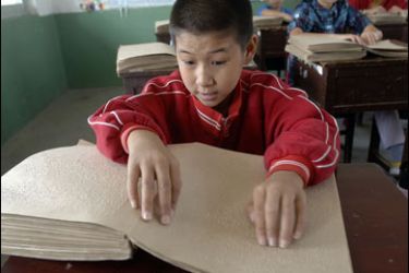 AFP PHOTO/A group of blind children read Chinese braille, which is based on the sounds of the language, as there are no braille signs for individual Chinese characters, at one of the only school for the blind in Hefei, central China's Anhui province 23 September 2007.