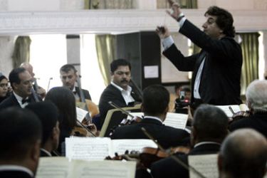 R/ Iraqi conductor Mohammed Ameen Izzat leads Iraq's National Symphony Orchestra (INSO) as they perform before an audience in the hall of Hunting Social club in Baghdad October 25, 2007.