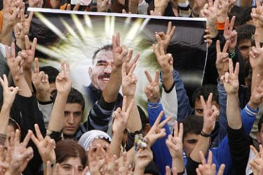 Kurdish supporters of DTP party flash victory signs as they hold up a portrait of jailed Kurdistan Workers Party (PKK) leader Abdullah Ocalan during a rally in the southeastern border Turkish town of Nusaybin