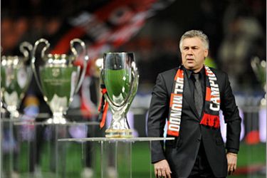 AFP / A.C. Milan's coach Carlo Ancelotti stands among of some of the 18 international tropies won by AC Milan, displayed on the pitch before an Italian serie A football match AC Milan vs