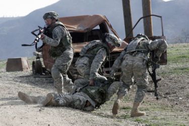 American troops move a soldier pretending to be dead in a simulated war environment at Fort Hunter Liggett, California, February 27, 2008. U.S. soldiers from 11 different units