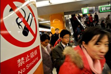 F/TO GO WITH: OLY-2008-CHN-COUNTDOWN-6MONTHS by Charles Whelan - Passengers walk past a no smoking sign on display at a subway station at the Central Business District (CBD) in Beijing, February 4, 2008. The transformation of much of Beijing into a concrete jungle can't be blamed entirely on the Olympics but the old city might have survived longer without the sporting extravaganza, according to experts. AFP PHOTO/TEH ENG KOON