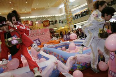 Participants compete in a wife-carrying obstacle race at a shopping mall in Hong Kong February 13, 2008 as part of the celebrations for Valentine's Day on February 14.