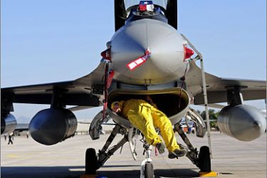 AFPA technician checks the turbines of a US Air Force F-16 during preparations for the
