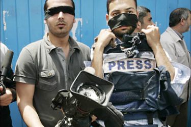 r_Palestinian journalists hold up the damaged camera and flack jacket of slain Reuters cameraman Fadel Shana during a protest in Gaza April 22, 208, against the killing of