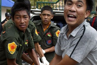 Rescuers rush towards an ambulance to shift a dead body from a site of shooting in Thailand's restive southern Pattani province on April 24, 2008