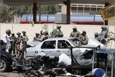 REUTERS/Iraqi and U.S. security forces gather at the scene of a bomb attack in Baghdad April 14, 2008. A blast in central Baghdad's Tayaran