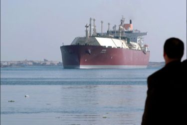 afp : An Egyptian man looks at the Qatari Liquefied Natural Gas (LNG) carrier "Duhail" as its passes through the Suez Canal near the Egyptian port city of Ismailia on April 1, 2008.