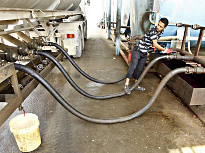 r/A Palestinian worker loads up fuel for a Gaza power plant near the Nahal Oz crossing May 12, 2008.