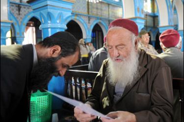 f/The first rabbi of Germany Ibraham Daos (L) stands opposite Rabbi Frazi Mazouz (R) as he reads the torah in the Ghriba Synagogue on May 20, 2008, on the southern