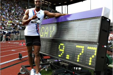 /AFP - Tyson Gay poses besides the sign board posting his new American record time of 9.77 in the men's 100 meter quarter-finals during day two of the U.S. Track and Field Olympic