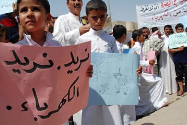 An Iraqi boy holds a placard that reads in Arabic 'We want electricity' during a rally in the southern port city of Basra on August 28, 2008 to demand reconnection of electricity.