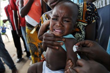afp : A health worker administers a yellow fever vaccine to a baby on August 27, 2008 on a roadside in Koumassi, a poor quartier of Abidjan after a case was discovered of yellow