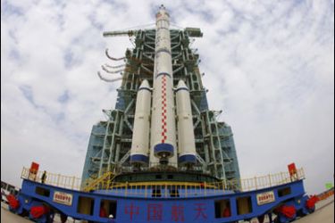 R/The Shenzhou-7 manned spaceship, the Long-March II-F rocket and the escape tower are transferred to the launch pad at Jiuquan Satellite Launch Center, Gansu province in this September 20, 2008 file photo.
