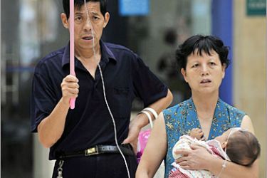 AFP - A Chinese couple with their baby under treatment at a hospital in Wuhan, central China's Hubei province on September 16, 2008. Police arrested two more suspects in