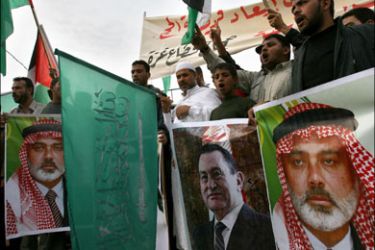 afp : Palestinian Muslims planning to go on pilgrimage to Mecca hold pictures of Palestinian Hamas leader Ismail Haniya and Egyptian President Hosni Mubarak (C) during a