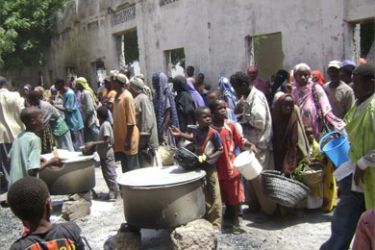 Somali internally displaced people (IDPs) wait in line to receive food at a makeshift camp on November 25, 2008 in Eleshabiyaha, 15 kms south of Mogadishu