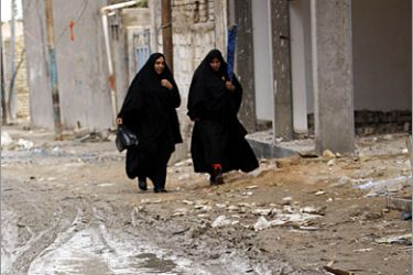 AFP - Iraqi women walk in a muddy street in the city of Fallujah 50kms west of the capital Baghdad on October 30 2008. In 2004 Fallujah was virtually razed to the ground by a massive US assault triggered when four security guards of US-based
