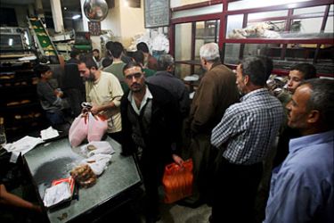 epa01555332 Palestinians wait to buy bread from al Shanti Bakrey in Gaza City, 19 November 2008. Thirty-three trucks with medical supplies and basic food