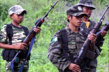 afp : (FILES) Photo taken on May 19, 2007 shows a young Muslim separatist rebel (L) of the Moro Islamic Liberation Front (MILF) carrying a firearm and ammunition pack in a
