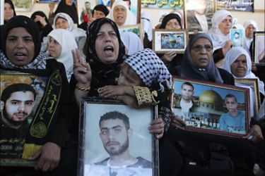 f_Palestinian women hold up photographs of relatives being held in an Israeli jail during a demonstration in Gaza City on December 1, 2008, calling for the release of detainees
