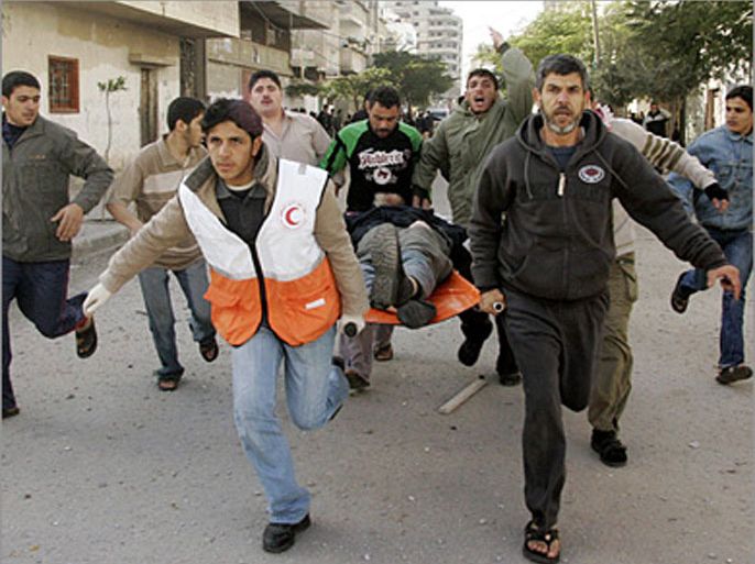 REUTERS / Palestinians run as they carry a wounded man after an Israeli air strike in Gaza January 2, 2009. Israeli warplanes struck targets in Gaza on Friday and Islamist fighters fired rockets into the Israeli port of Ashkelon, dashing international hopes