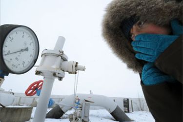 A woman looks at a manometer set on a gas pipe of the gas-compressor station in the small Ukrainian city of Boyarka, near Kiev on January 4, 2009