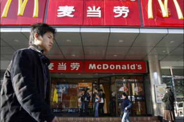 r : A man walks past a McDonald's outlet in Beijing in this April 2, 2007 file photo. China's office workers are tightening their belt, cutting back spending on everything from clothes to