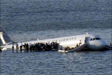 r : Passengers stand on the wings of a U.S. Airways plane as a ferry pulls up to it after it landed in the Hudson River in New York, January 15, 2009. Local media said the plane